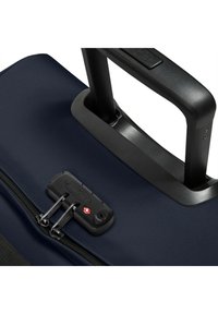 Mörkblå rullväska med ett robust svart handtag, dubbel dragkedjestängning och kombinationslås för säkerhet. Texturerad tygyta.
