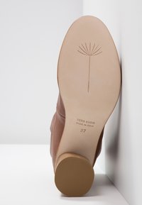 Semelle d'une chaussure en cuir marron avec un logo de pissenlit, "Vero Cuoio Made in Italy," et taille 37 avec un talon rond beige.