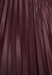 Tissu en satin plissé d'un bordeaux profond avec des plis verticaux uniformément espacés créant une texture lisse et brillante.