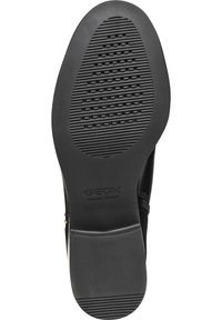 Black rubber shoe sole featuring a textured grid pattern and raised ridges. Geox logo embossed near the heel for branding.