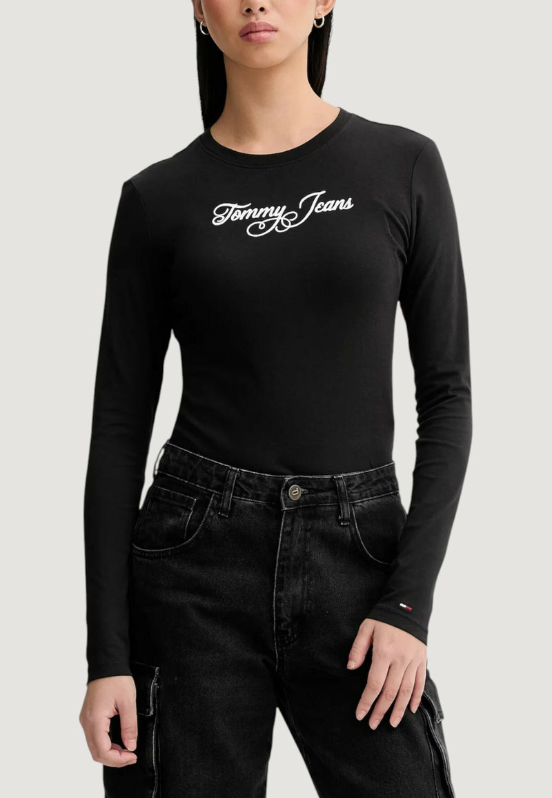 Czarna koszula z długim rękawem z białym logo "Tommy Jeans". Wykonana z gładkiej bawełnianej tkaniny, o dopasowanym kroju i okrągłym dekolcie.