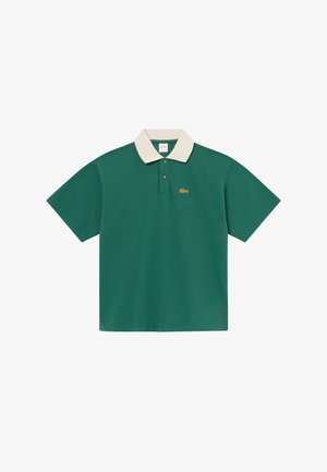 Zöld rövid ujjú galléros póló krém színű gallérral, kéttagú gombolószalaggal és kis sárga hímzett logóval a bal mellrészen.