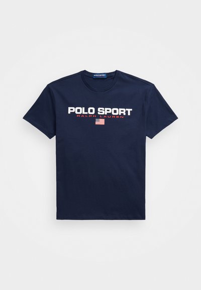 T-shirt de algodão azul marinho com o texto forte em branco "POLO SPORT", "RALPH LAUREN" em menor escala, e um detalhe em vermelho com um emblema da bandeira americana.