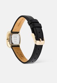 Bracelet de montre en cuir noir avec un boîtier en acier inoxydable doré. Cadran carré, affichage clair et boucle ajustable avec initiales gravées.