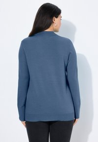 Modrý pletený svetr s dlouhými rukávy, se žebrovaným lemem a hladkou texturou. Pohled z zad ukazuje uvolněný střih a jednoduchý design.