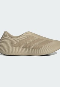 Μπεζ αθλητικό παπούτσι με κομψό, λεία σχεδίαση, με τρεις ανάγλυφες ρίγες και υφασμένες πλευρές με ραβδώσεις για καλύτερη πρόσφυση. Καμπυλωτή σιλουέτα.