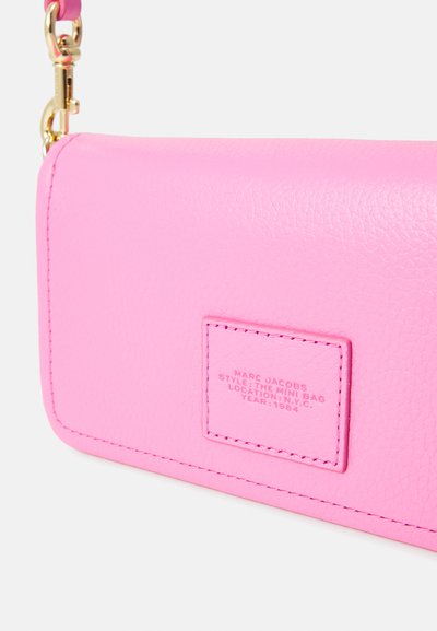 Pink leather mini bag with textured finish, stamped label, and gold hardware. Features a detachable strap and rectangular shape.