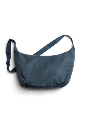 Sac bandoulière bleu marine avec sangle réglable et petit logo de la marque sur le devant, sur fond blanc.