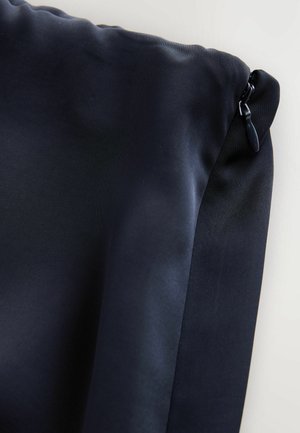 Navy blue pouch made of smooth, matte fabric with a zipper closure. Features a textured side panel and a glossy zipper pull.