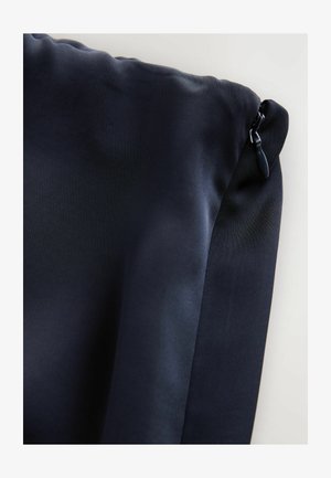 Navy blue pouch made of smooth, matte fabric with a zipper closure. Features a textured side panel and a glossy zipper pull.