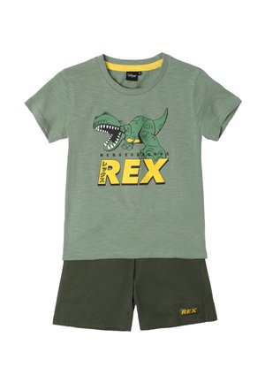 Camiseta verde de manga corta con un gráfico de dinosaurio y el texto "Nervous REX", combinada con pantalones cortos verde oscuro con la etiqueta "REX".