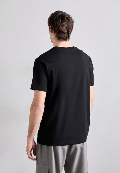 T-shirt noir à manches courtes en coton, avec col rond et coupe décontractée, au toucher lisse et légèrement extensible.