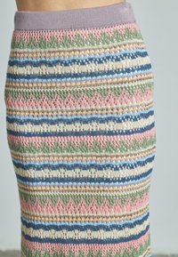 Gebreide rok met een meerkleurig gestreept patroon in roze, groen, blauw en crème, met een gestructureerd, kantachtig ontwerp en een paarse tailleband.