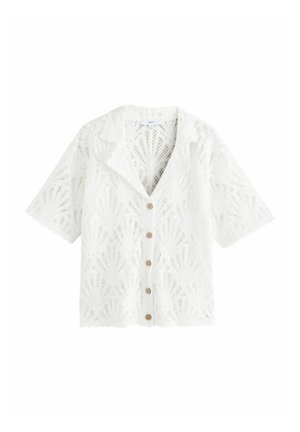 Biały krótki kardigan z krótkim rękawem wykonany z koronki z falistymi krawędziami, wzorem kwiatowym, brązowymi guzikami i spiczastym kołnierzykiem.