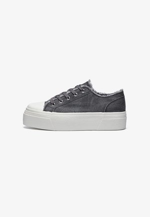 Gray denim sneakers with a white rubber sole, featuring a frayed edge at the ankle, gray laces, and metal eyelets.