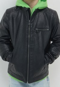 Czarna skórzana kurtka z zamkiem z przodu, dwoma bocznymi kieszeniami i jedną kieszenią na klatce piersiowej. Posiada prążkowane akcenty na rękawach oraz gładką strukturę.
