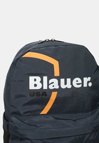Zaino nero in nylon con parte superiore curva, audace logo bianco e arancione "Blauer. USA" e una texture liscia con chiusura a zip.