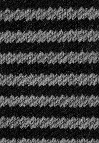 Schwarz-grauer gestreifter Stoff mit einem strukturierten Strickmuster, das abwechselnde Farbstreifen zeigt und einen deutlichen Kontrast erzeugt.