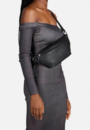 Sorte læder crossbody taske med en buet form, lynlåslukning og aftagelig rem. Den fremhævede tag-accent tilføjer detalje.