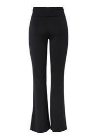 Zwarte yoga broek voor dames met hoge taille, brede tailleband en licht uitlopende pijpen, gezien van achteren tegen een witte achtergrond.