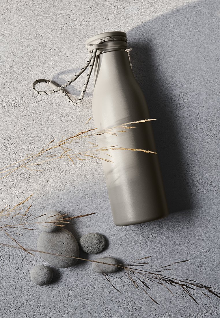 Botella de agua de acero inoxidable gris con un acabado mate suave, presenta una correa texturizada y un diseño minimalista, situada sobre una superficie texturizada.