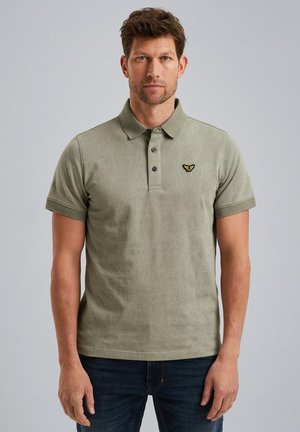Polo-shirt vert olive avec motif texturé, patte de boutonnage à trois boutons et manches courtes. Présente un petit logo brodé sur la poitrine.