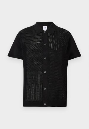 Polo noir à manches courtes avec un tricot texturé et perforé à l'avant. Il présente un col uni et des boutons sur le devant.