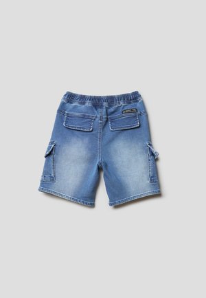 Pantalones cortos cargo de mezclilla azul con cintura elástica y bolsillos con solapa en la parte trasera y a los lados, mostrados desde atrás sobre un fondo liso.