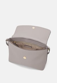 Grijze leren handtas met een soepele textuur, gouden hardware, open bovenkant en een enkel compartiment bekleed met een beige stoffen binnenkant.