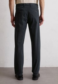 Pantalons gris foncé au design droit, fabriqués en tissu texturé, dotés de deux poches arrière et d'une taille confortable.