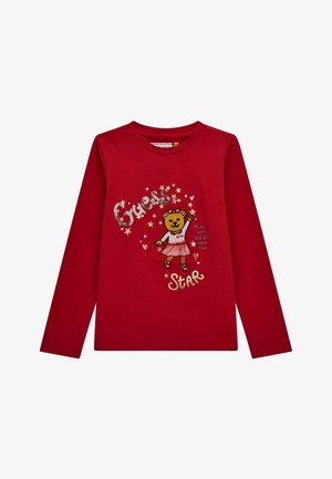 Rød langærmet skjorte med en bjørn iført nederdel, teksten "Guess Star", stjerner, hjerter og sætningen "Make a wish and it’ll come true."