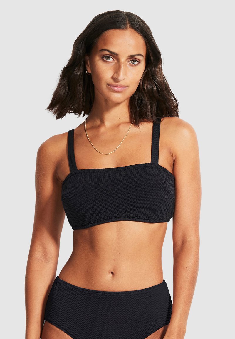 Svart teksturert bikini topp med rette stropper, med et rektangulært utseende og sydd kanter. Båret med matchende svarte underdeler.