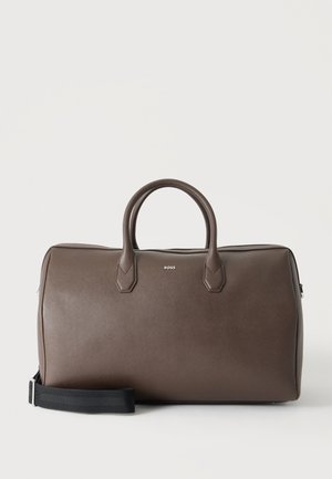 Καφέ δερμάτινη τσάντα duffel με δύο λαβές, μαύρο ρυθμιζόμενο λουρί ώμου και μικρό λογότυπο "BOSS" στο κέντρο μπροστά.