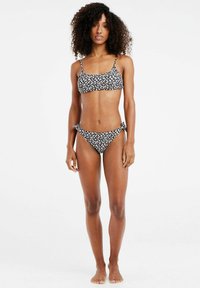 Bikini nero con motivo floreale, composto da un top bralette e slip con legatura laterale, realizzato in tessuto morbido con un design aderente.