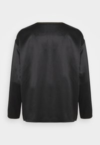 Haut noir en satin à manches longues avec un col rond. Texture lisse et lignes épurées. Aucun élément métallique ou motif visible.