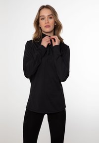 Pullover nero a maniche lunghe con zip a quarto, realizzato in tessuto liscio. Presenta un dettaglio con logo sul colletto e una vestibilità rilassata.