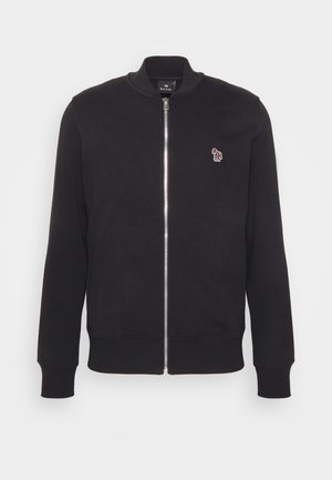 Črni zip-up pulover z ribanim ovratnikom in manšeti, izdelan iz mehkega materiala, z majhnim vezenim logotipom na levem prsnem delu.