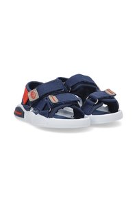 Sandalias de color azul marino con correas ajustables, suelas blancas y acentos rojos. Fabricadas en tela y goma, cuentan con un sistema de cierre de velcro.