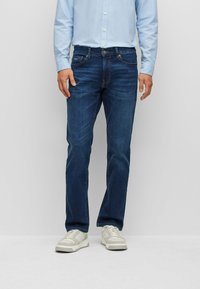 Dark blue denim jeans with a straight leg cut, standard five-pocket design, and subtle stitching details on waistband and pockets.