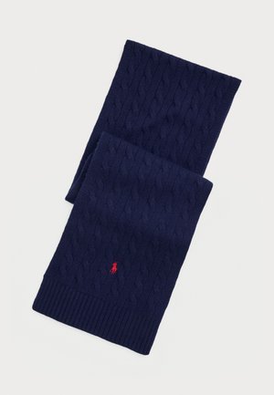 Écharpe en tricot câblé bleu marine avec un bord côtelé et un petit logo rouge brodé près de l'extrémité.