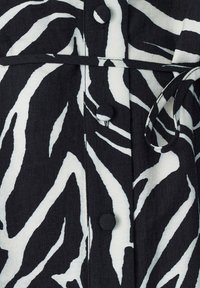 Mustvalge zebra-ribadega särk-kleit, millel on tekstureeritud kangas, vöö sidumiseks, nupud ja kraega kaelus.