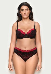 Set di reggiseno e slip neri con dettagli in pizzo rosso. Il reggiseno presenta ferretti e bordi ondulati, mentre gli slip hanno un cinturino in pizzo coordinato.