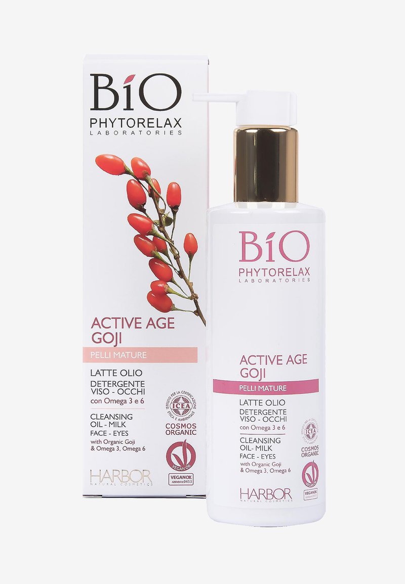 Butelka z olejem-mlekiem oczyszczającym z białego plastiku, z złotą pompką. Etykieta z różowym tekstem i grafiką jagód goji. Opakowanie w kartonowym pudełku.