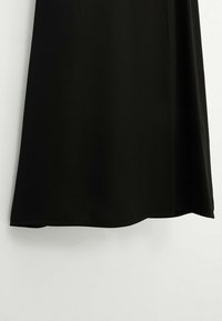 Tissu noir avec un ourlet droit, montrant une texture lisse et un léger tombé sur un fond blanc.