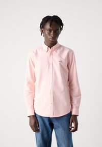 Camicia rosa chiaro a maniche lunghe con colletto classico, caratterizzata da un piccolo logo rosso "BOSS" sul petto e una texture di cotone liscia.