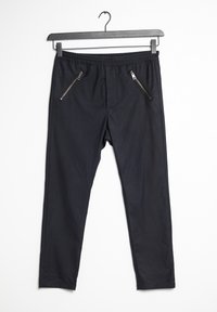 Svarta byxor med elastisk midja, två fickor med dragkedja framtill, slim fit och en jämn tygtextur.