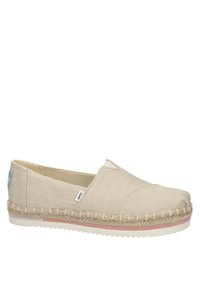 Beige canvas slip-on shoes with a braided jute midsole, rubber outsole, and a small blue tag on the side. Rounded toe, minimal stitching.