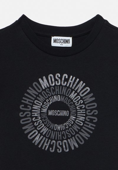 Black crew-neck shirt with a circular repeating "MOSCHINO" logo in silver glitter and a white Moschino Kid label inside the collar.