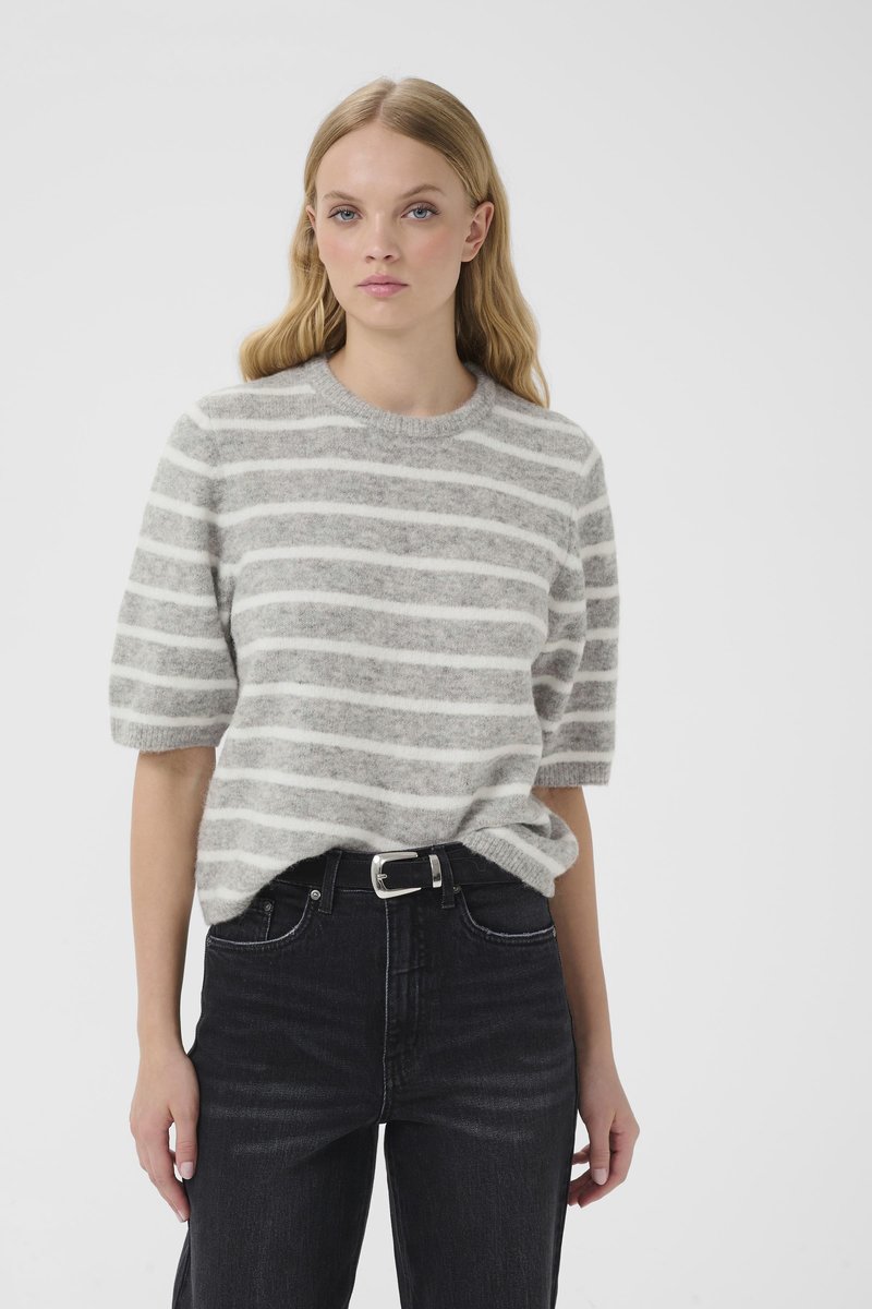 Maglione a maniche corte a righe grigie e bianche con scollatura tonda, abbinato a jeans neri a vita alta e cintura argentata.