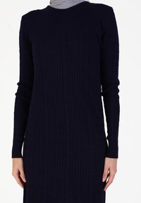 Knit long-sleeve dress in dark navy with a textured ribbed pattern, featuring a round neck and fitted silhouette.